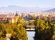 Vista aérea de Pamplona con el puento sobre el río y los edificios al fondo.