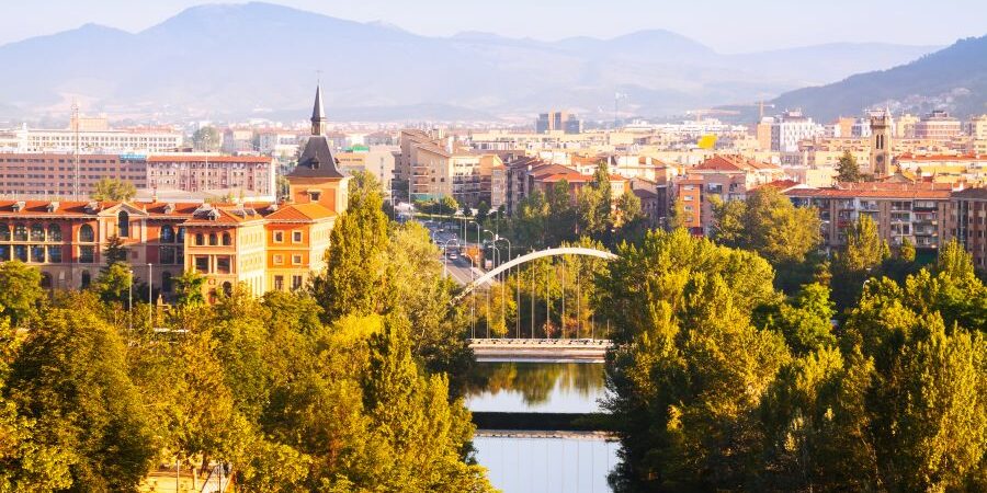 Vista aérea de Pamplona con el puento sobre el río y los edificios al fondo.